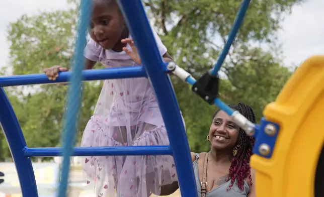 Tamika Davis, right, spends time with her daughter, Shanara, 3, at MLK Park in San Antonio, Thursday, May 30, 2024. Davis said friends and family watched her kids for most of her doctor visits during treatment last year for colon cancer. But she couldn't afford additional childcare, and she didn't know where to look for assistance. (AP Photo/Eric Gay)