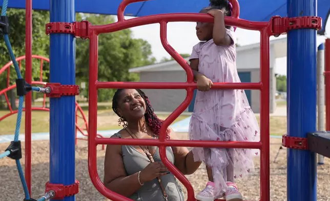 Tamika Davis, right, spends time with her daughter, Shanara, 3, at MLK Park in San Antonio, Thursday, May 30, 2024. Davis said friends and family watched her kids for most of her doctor visits during treatment last year for colon cancer. But she couldn't afford additional childcare, and she didn't know where to look for assistance. (AP Photo/Eric Gay)