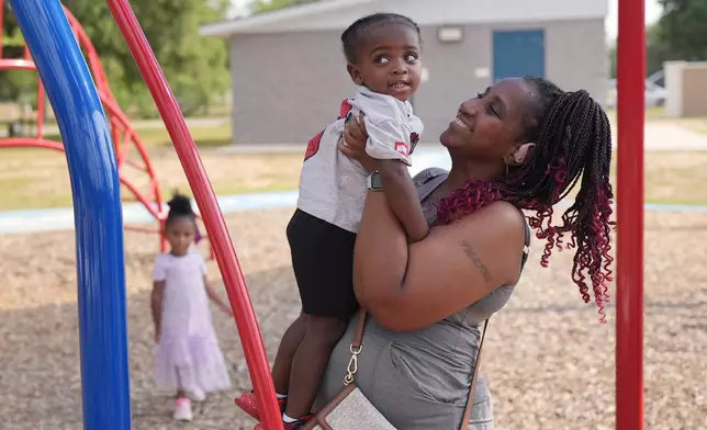 Tamika Davis, right, spends time with her children, Lionel Jr., 2, centers and Shanara, 3, left at MLK Park in San Antonio, Thursday, May 30, 2024. Davis said friends and family watched her kids for most of her doctor visits during treatment last year for colon cancer. But she couldn't afford additional childcare, and she didn't know where to look for assistance. (AP Photo/Eric Gay)