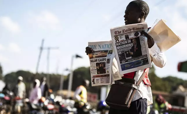 A vendor sells newspapers in Lilongwe, Malawi, Wednesday, June 12, 2024, following the death of Malawi's Vice President, Saulos Chilima, in a plane crash Monday. The Malawi government says that Chilima will be honored with a state funeral after he was killed along with eight other people in a plane crash. (AP Photo/Thoko Chikondi)