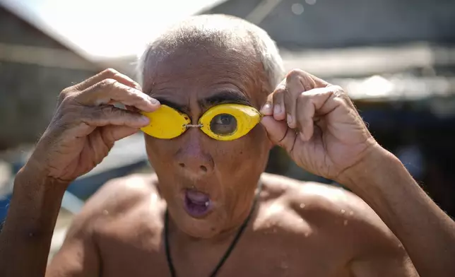 Jesus Culis adjusts his swimming goggles at the coastal village of Simlong in Batangas province, Philippines on Tuesday, Aug. 8, 2023. He lost his vision on one eye during a childhood accident. (AP Photo/Aaron Favila)