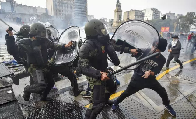 Anti-government protesters clash with police outside Congress, as lawmakers debate a reform bill promoted by Argentine President Javier Milei in Buenos Aires, Argentina, Wednesday, June 12, 2024. (AP Photo/Gustavo Garello)