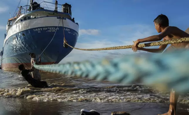 Children play with the ropes of a ship docked on a beach in Parika, Guyana, Sunday, June 9, 2024. (AP Photo/Ramon Espinosa)