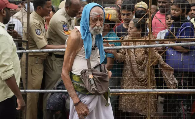 An asthma patient arrives to receive a fish therapy as others stand in a queue, in Hyderabad, India, Saturday, June 8, 2024. Every year thousands of asthma patients arrive here to receive this fish therapy from the Bathini Goud family, a secret formula of herbs, handed down by generations only to family members. The herbs are inserted in the mouth of a live sardine, or murrel fish, and slipped into the patient's throat. (AP Photo/Mahesh Kumar A.)