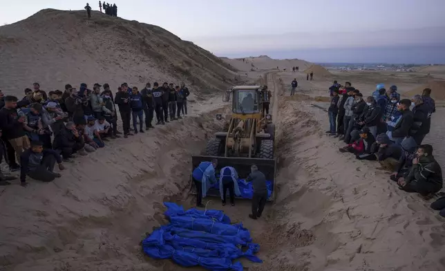 FILE - A bulldozer unloads the bodies of Palestinians killed in fighting with Israel and turned over by the Israeli military during a mass funeral in Rafah, Gaza Strip, Tuesday, Dec. 26, 2023. (AP Photo/Fatima Shbair, File)