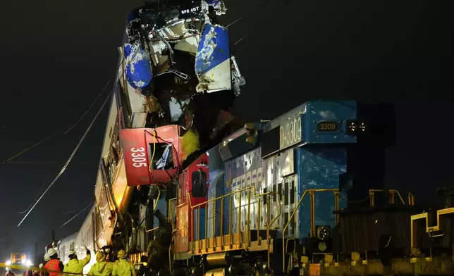 Police inspect the crash site where a freight train collided head-on with another train on a test run, in San Bernardo, on the outskirts of Santiago, Chile, June 20, 2024. (AP Photo/Esteban Felix)