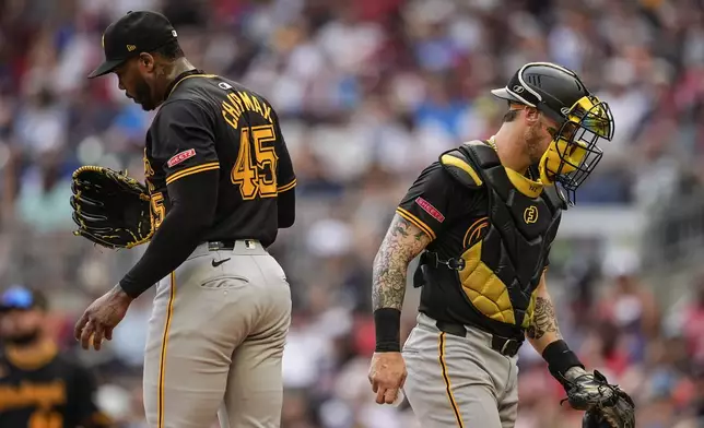 Pittsburgh Pirates catcher Yasmani Grandal (6) leaves the mound after speaking with Aroldis Chapman (45) in the nineth inning of a baseball game against the Atlanta Braves, Saturday, June 29, 2024, in Atlanta. (AP Photo/Mike Stewart)