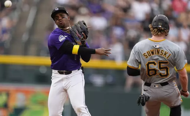 Colorado Rockies second baseman Adael Amador, left, throws to first base after putting out Pittsburgh Pirates' Jack Suwinski, right, at second on the front end of a double play hit into by Jared Triolo to end the top of the second inning of a baseball game Friday, June 14, 2024, in Denver. (AP Photo/David Zalubowski)