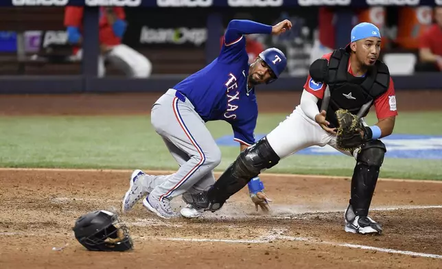 Miami Marlins catcher Johnny Pereda, right, forces out Texas Rangers' Marcus Semien, left, during the ninth inning of a baseball game, Saturday, June 1, 2024, in Miami. (AP Photo/Michael Laughlin)