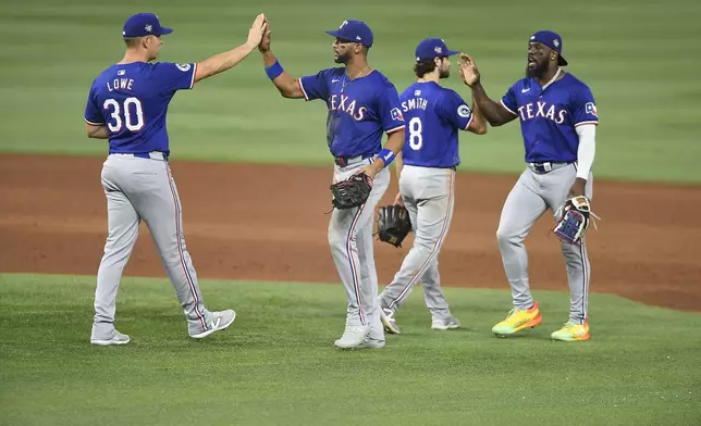 From left to right, Texas Rangers' Nathaniel Lowe, Leody Taveras, Josh Smith and Adolis García celebrate after defeating the Miami Marlins in a baseball game, Saturday, June 1, 2024, in Miami. (AP Photo/Michael Laughlin)