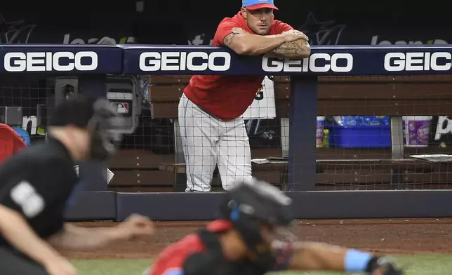 Miami Marlins manager Skip Schumaker, top, watches his team play the Texas Rangers during the ninth inning of a baseball game, Saturday, June 1, 2024, in Miami. (AP Photo/Michael Laughlin)