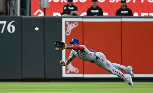 Texas Rangers center fielder Derek Hill makes a diving catch on a ball hit by Baltimore Orioles' Adley Rutschman during the first inning of a baseball game, Saturday, June 29, 2024, in Baltimore. (AP Photo/Terrance Williams)