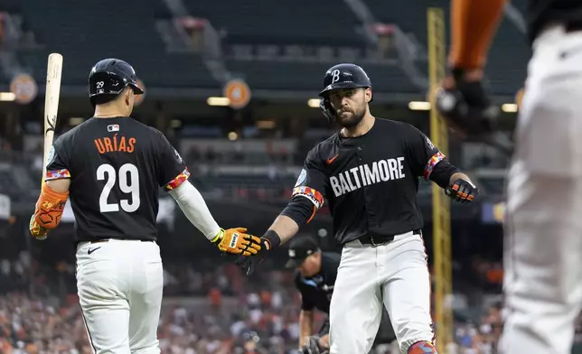 Baltimore Orioles' Colton Cowser, right, celebrates with Ramon Urias (29) after hitting a home run against the Texas Rangers during the fourth inning of a baseball game Friday, June 28, 2024, in Baltimore. (AP Photo/Stephanie Scarbrough)