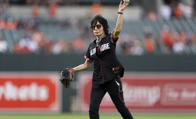 Rock and roll music icon Joan Jett throws the ceremonial first pitch before a baseball game between the Baltimore Orioles and the Texas Rangers, Friday, June 28, 2024, in Baltimore. (AP Photo/Stephanie Scarbrough)