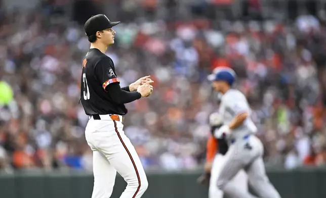 Baltimore Orioles pitcher Cade Povich, left, looks on after surrendering a solo home run to Texas Rangers' Corey Seage, right,r during the first inning of a baseball game, Saturday, June 29, 2024, in Baltimore. (AP Photo/Terrance Williams)