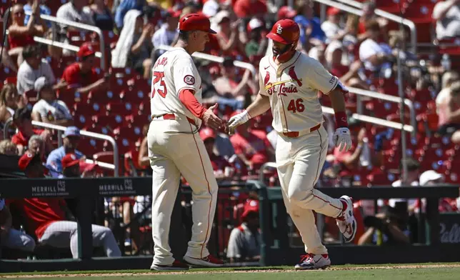 St. Louis Cardinals' Paul Goldschmidt (46) is congratulated by third base coach Ron 'Pop' Warner, left, after hitting a solo home run in the sixth inning of a baseball game against the Cincinnati Reds, Saturday, June 29, 2024, in St. Louis. (AP Photo/Joe Puetz)