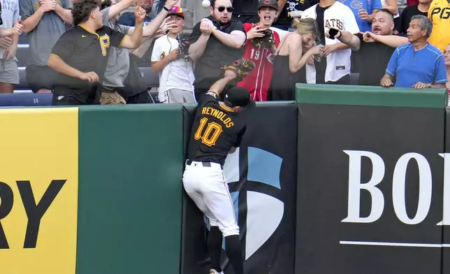 Pittsburgh Pirates left fielder Bryan Reynolds can't make the catch on a two-run home run by Cincinnati Reds' Santiago Espinal during the fifth inning of a baseball game in Pittsburgh, Tuesday, June 18, 2024. (AP Photo/Gene J. Puskar)