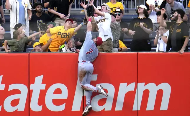 Cincinnati Reds left fielder Spencer Steer leaps for but can't come down with a ball hit for a solo home run by Pittsburgh Pirates' Ke'Bryan Hayes during the seventh inning of a baseball game in Pittsburgh, Tuesday, June 18, 2024. (AP Photo/Gene J. Puskar)