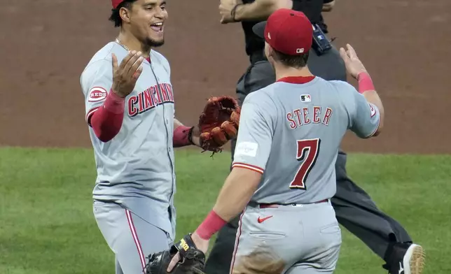 Cincinnati Reds' Santiago Espinal, left, celebrates with Spencer Steer (7) after getting the final out of a baseball game against the Pittsburgh Pirates in Pittsburgh, Tuesday, June 18, 2024. The Reds won 2-1. (AP Photo/Gene J. Puskar)