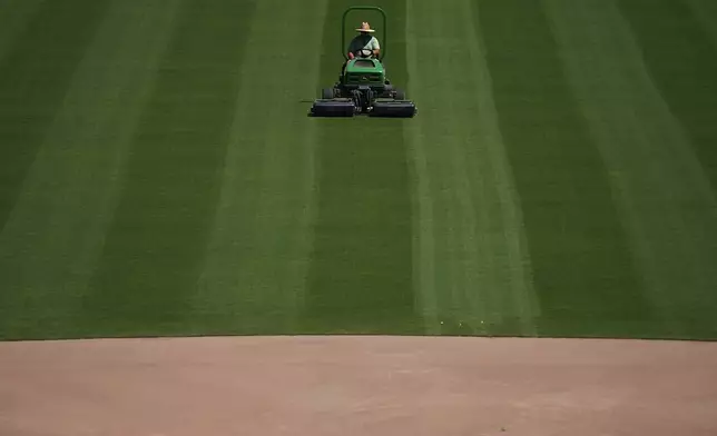 A grounds keeper tends to the field, mowing the outfield grass at Rickwood Field, Monday, June 10, 2024, in Birmingham, Ala. Rickwood Field, known as one of the oldest professional ballpark in the United States and former home of the Birmingham Black Barons of the Negro Leagues, will be the site of a special regular season game between the St. Louis Cardinals and San Francisco Giants on June 20, 2024. (AP Photo/Brynn Anderson)