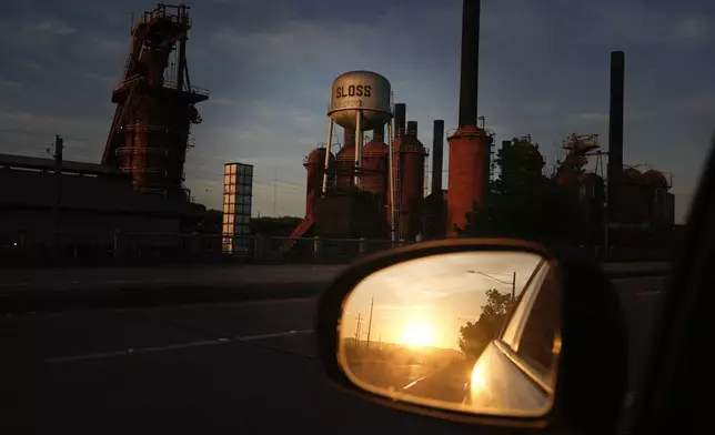 The sun rises over the horizon near the Sloss Furnaces National Historic Landmark in Birmingham, Ala, on Tuesday, June 11, 2024. Birmingham will host a regular season MLB baseball game at Rickwood Field. It's known as one of the oldest professional ballpark in the United States and former home of the Birmingham Black Barons of the Negro Leagues. The game between the St. Louis Cardinals and San Francisco Giants is set to be played on June 20, 2024. (AP Photo/Brynn Anderson)