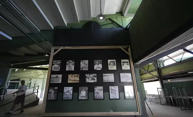 A person walks by a Rickwood Field, "hall of fame," said to be former players of the baseball field, Monday, June 10, 2024, in Birmingham, Ala. Rickwood Field, known as one of the oldest professional ballpark in the United States and former home of the Birmingham Black Barons of the Negro Leagues, will be the site of a special regular season game between the St. Louis Cardinals and San Francisco Giants on June 20, 2024. (AP Photo/Brynn Anderson)