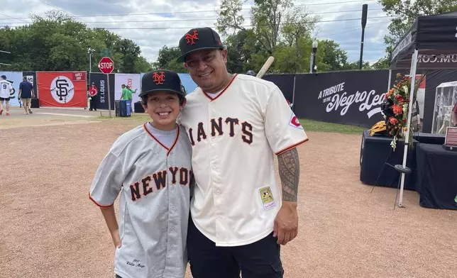 Eddie Torres, right, and son Junior, from California and wearing San Francisco Giants uniforms with Willie Mays' No. 24 on the back, pose at Rickwood Field on Thursday, June 20, 2024, in Birmingham, Ala. (AP Photo/Alanis Thames)