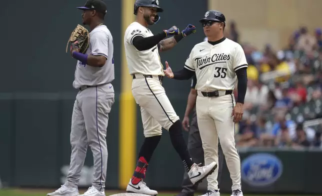 Minnesota Twins' Carlos Correa, center, celebrates after hitting a single during the eighth inning of a baseball game against the Colorado Rockies, Wednesday, June 12, 2024, in Minneapolis. (AP Photo/Abbie Parr)