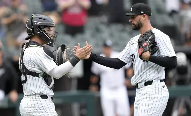 Chicago White Sox catcher Korey Lee and relief pitcher Justin Anderson celebrate the team's 11-3 win over the Colorado Rockies following a baseball game Saturday, June 29, 2024, in Chicago. (AP Photo/Charles Rex Arbogast)
