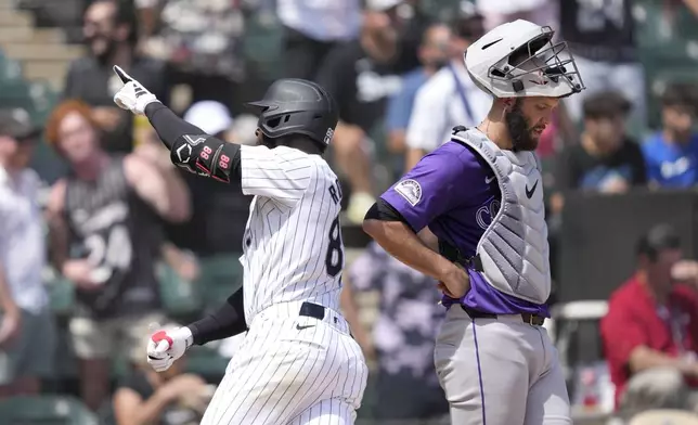Chicago White Sox's Luis Robert Jr., left, celebrates his home run off Colorado Rockies starting pitcher Cal Quantrill, as catcher Jacob Stallings waits for play to resume in the sixth inning of a baseball game Saturday, June 29, 2024, in Chicago. (AP Photo/Charles Rex Arbogast)