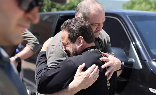 In this photo released by The Telegram Channel of the administration of the head of Dagestan Republic of Russia on Monday, June 24, 2024, the head of Dagestan Republic Sergei Melikov, center, embraces and comforts a priest as he visits the Orthodox Church of the Intercession of the Blessed Virgin Mary in Derbent after a counter-terrorist operation in republic of Dagestan, Russia. Multiple police officers and several civilians, including an Orthodox priest, were killed by armed militants in Russia's southern republic of Dagestan on Sunday, its governor Sergei Melikov said in a video statement early Monday. (The Telegram Channel of the administration of the head of Dagestan Republic of Russia via AP)