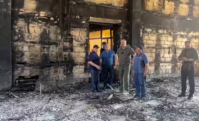 In this photo taken from video released by The Telegram Channel of the head of Dagestan Republic of Russia on Monday, June 24, 2024, the head of Dagestan Republic Sergei Melikov, center, visits the damaged the Kele-Numaz synagogue in Derbent after a counter-terrorist operation in republic of Dagestan, Russia. More than 15 police officers and several civilians, including an Orthodox priest, were killed by armed militants in Russia's southern republic of Dagestan on Sunday, its governor Sergei Melikov said in a video statement early Monday. The gunmen opened fire on two Orthodox churches, a synagogue and a police post in two cities, according to the authorities. (The Telegram Channel of the head of Dagestan Republic of Russia via AP)
