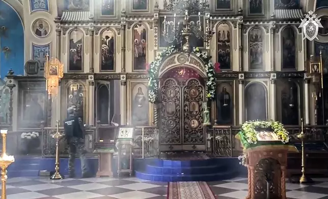 In this photo taken from video released by Russian Investigative Committee on Monday, June 24, 2024, a Russian Investigative Committee employee works inside a damaged by armed militants Orthodox Church in Makhachkala after a counter-terrorist operation in republic of Dagestan, Russia. Multiple police officers and several civilians, including an Orthodox priest, were killed by armed militants in Russia's southern republic of Dagestan on Sunday, its governor Sergei Melikov said in a video statement early Monday. (Russian Investigative Committee via AP)