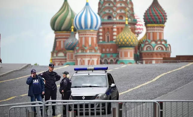 FILE - Police officers stand next to their car in an empty Red Square with St. Basil's Cathedral in the background in Moscow, Russia, on June 28, 2023. Life has returned to normal in the capital after a brief armed rebellion by mercenary chief Yevgeny Prigozhin on June 23-24, 2023. (AP Photo/Alexander Zemlianichenko, File)