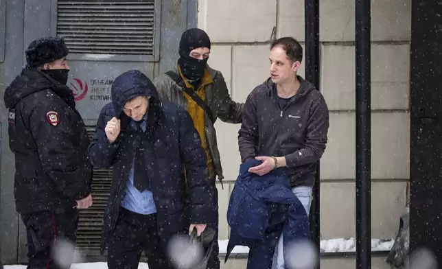 FILE - Wall Street Journal reporter Evan Gershkovich, right, is escorted from court in Moscow, Russia, on Jan. 26, 2024. The 32-year-old journalist faces trial Wednesday, June 26, on espionage charges that he, his employer and the U.S. government deny. He was detained in March 2023 while reporting in the city of Yekaterinburg and accused of spying. (AP Photo/Alexander Zemlianichenko, File)