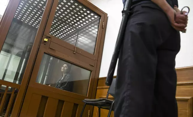 FILE - Ksenia Karelina, also known as Khavana sits in a defendants’ cage in a court in Yekaterinburg, Russia, on June 20, 2024. Khavana, 33, was arrested in February on treason charges, accused of collecting money for Ukraine's military. Independent Russian news outlet Mediazona identified her as Ksenia Karelina, her maiden name, and said she had U.S. citizenship after marrying an American. She had returned to Russia from Los Angeles to visit family. The rights group Pervy Otdel said the charges stem from a $51 donation to a U.S. charity that helps Ukraine. (AP Photo, File)