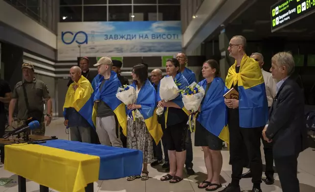 Nariman Dzhelyal, second right, deputy head of the Mejlis of the Crimean Tatar People stands among with other prisoners who have been recently released in Kyiv airport, Ukraine, Saturday, June 29, 2024. Ten Ukrainians who had been held prisoners for years, were released from Russian captivity on Friday with a mediation of Vatican, said Ukraine's President Volodymyr Zelenskyy. (AP Photo/Alex Babenko)