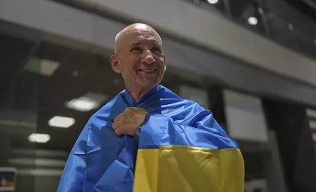 Priest Bohdan Heleta, who was detained inside his own church in the occupied city of Berdiansk in the Zaporizhzhia region in 2022, smiles at Kyiv airport in Kyiv, Ukraine, Saturday, June 29, 2024. Ten Ukrainians who had been held prisoners for years, were released from Russian captivity on Friday with a mediation of Vatican, said Ukraine's president Volodymyr Zelenskyy. (AP Photo/Alex Babenko)
