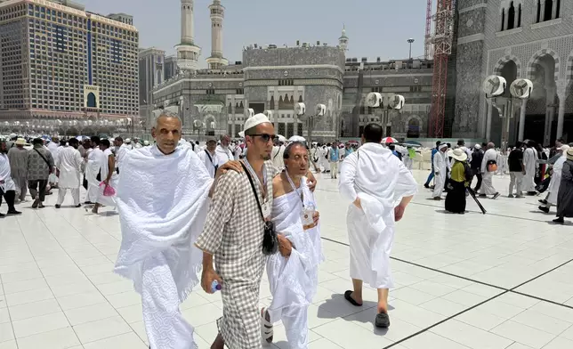 Two blind pilgrims preform Hajj with the help of their guide outside of the Grand Mosque during the annual pilgrimage in Mecca, Saudi Arabia, Thursday, June 13, 2024. Hajj is the annual Islamic pilgrimage to Mecca in Saudi Arabia that is required once in a lifetime of every Muslim who can afford it and is physically able to make it. Some Muslims make the journey more than once. (AP Photo/Baraa Anwer)