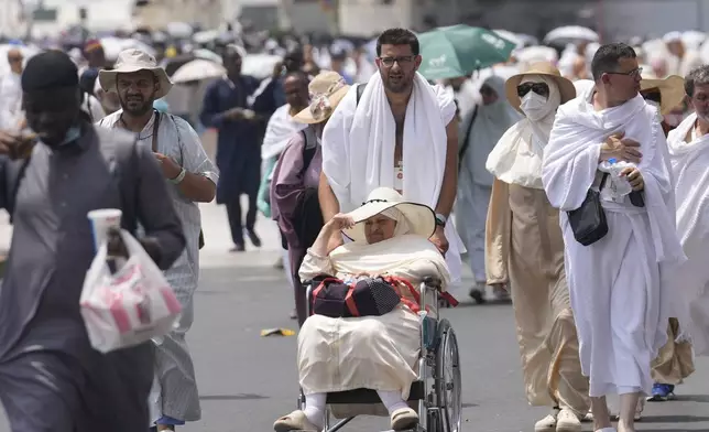 Pilgrims leave after offering prayers outside at the Grand Mosque, during the annual Hajj pilgrimage in Mecca, Saudi Arabia, Thursday, June 13, 2024. Hajj is the annual Islamic pilgrimage to Mecca in Saudi Arabia that is required once in a lifetime of every Muslim who can afford it and is physically able to make it. Some Muslims make the journey more than once. (AP Photo/Rafiq Maqbool)