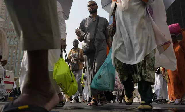 Pilgrims leave after offering prayers outside at the Grand Mosque during the annual Hajj pilgrimage in Mecca, Saudi Arabia, Thursday, June 13, 2024. Hajj is the annual Islamic pilgrimage to Mecca in Saudi Arabia that is required once in a lifetime of every Muslim who can afford it and is physically able to make it. Some Muslims make the journey more than once. (AP Photo/Rafiq Maqbool)
