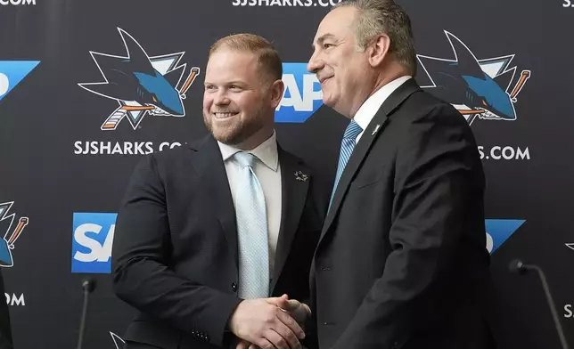 Ryan Warsofsky, left, shakes hands with San Jose Sharks president Jonathan Becher at a news conference introducing Warsofsky as the NHL hockey head coach of the Sharks in San Jose, Calif., Monday, June 17, 2024. (AP Photo/Jeff Chiu)