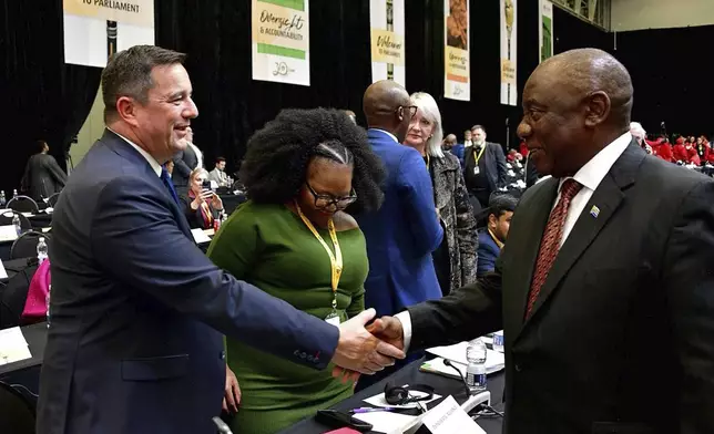 In this photo provided by the South African Government Communication and Information System, (GCIS), South African Président Cyril Ramaphosa, right, greets opposition Democratic Alliance (DA) leader, John Steenhuisen, left, at the first sitting of Parliament since elections, in Cape Town, South Africa, Friday, June 14, 2024. In a country where racial segregation was once brutally enforced, South Africa's new coalition government has brought a Black president and a white opposition leader together in what is on the face of it a picture of unity. (South African GCIS via AP)