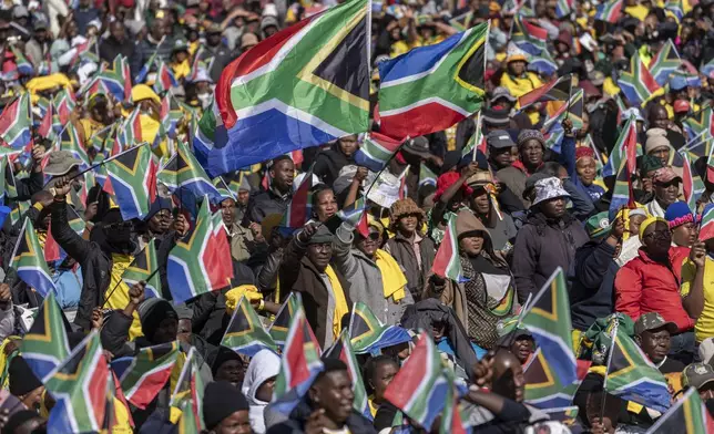 FILE - South Africans cheer ahead of the inauguration of South Africa's Cyril Ramaphosa as President at the Union Buildings South Lawns in Pretoria, South Africa, on June 19, 2024. In a country where racial segregation was once brutally enforced, South Africa's new coalition government has brought a Black president and a white opposition leader together in what is on the face of it a picture of unity. (AP Photo/Jerome Delay, File)