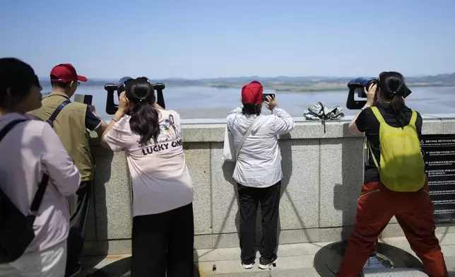 Visitors use binoculars to see the North Korean side from the unification observatory in Paju, South Korea, Tuesday, June 4, 2024. South Korea’s government has approved the suspension of a contentious military agreement with North Korea, a step that would allow it to take tougher responses to North Korean provocations. (AP Photo/Lee Jin-man)