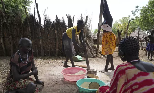Women work with flour in Otallo village, South Sudan, Wednesday, June 19, 2024. African Parks has set up small hubs in several remote villages and is spreading messages of sustainable practices, such as not killing female or baby animals. (AP Photo/Brian Inganga)