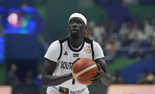 FILE - South Sudan forward Nuni Omot looks to shoot against Puerto Rico during a Basketball World Cup group B match in Quezon City, Philippines,, Aug. 26, 2023. “A lot of guys are refugees. And we grew up, we moved, so we’ve had the luxuries of having indoor courts and such things,” Omot said about the team. “To go back home and start kind of at the beginning, obviously, we all had a vision of what it could be. It’s just a testament that’s going to show in the future.” (AP Photo/Aaron Favila, File)