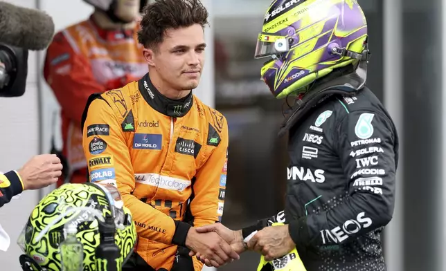 McLaren driver Lando Norris of Britain is congratulated by Mercedes driver Lewis Hamilton of Britain, after winning the pole position for the Formula 1 Spanish Grand Prix at the Barcelona Catalunya racetrack in Montmelo, near Barcelona, Spain, Saturday, June 22, 2024. (Thomas Coex, Pool Photo via AP)