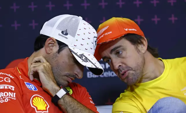 Aston Martin driver Fernando Alonso of Spain, right, speaks with Ferrari driver Carlos Sainz of Spain during a press conference at the Barcelona Catalunya racetrack in Montmelo, near Barcelona, Spain, Thursday June 20, 2024. The Spanish Grand Prix Formula One race will be held on Sunday. (AP Photo/Joan Monfort)