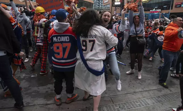 Edmonton Oilers fans celebrate the team's win over the Florida Panthers, as fans watched coverage of Game 5 of the NHL hockey Stanley Cup Final, Tuesday, June 18, 2024, in Edmonton, Alberta. (Jason Franson/The Canadian Press via AP)